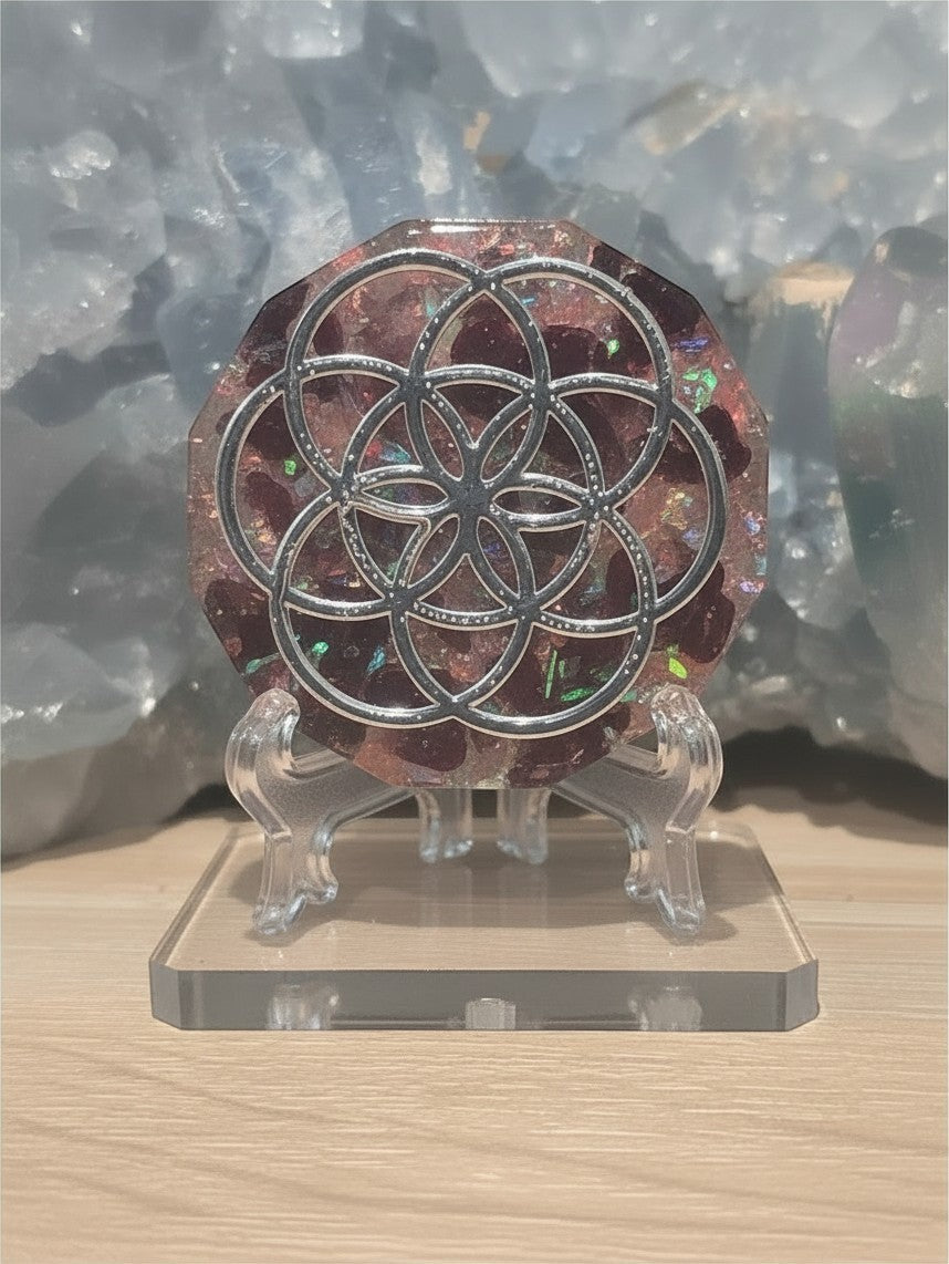 Pendentif orgonite AlyJoyCreation avec symbole Graine de Vie en métal argenté sur fond de résine rouge et paillettes
