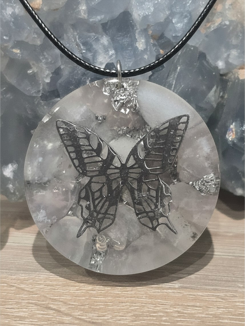 Pendentif AlyJoyCreation en orgonite ronde transparente avec un papillon métallique et des éclats argentés