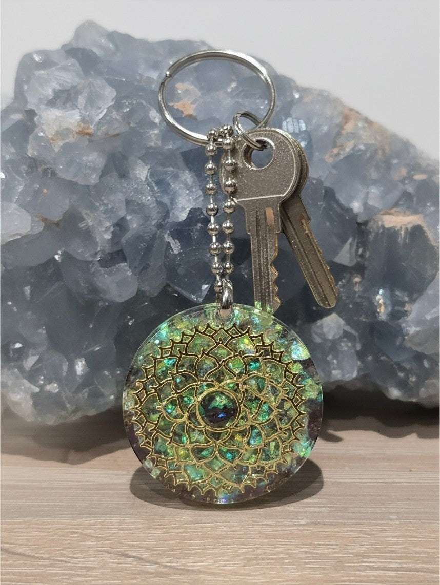 Porte-clés AlyJoyCreation en orgonite ronde avec motif rosace mandala doré, incrustations vertes et améthyste centrale